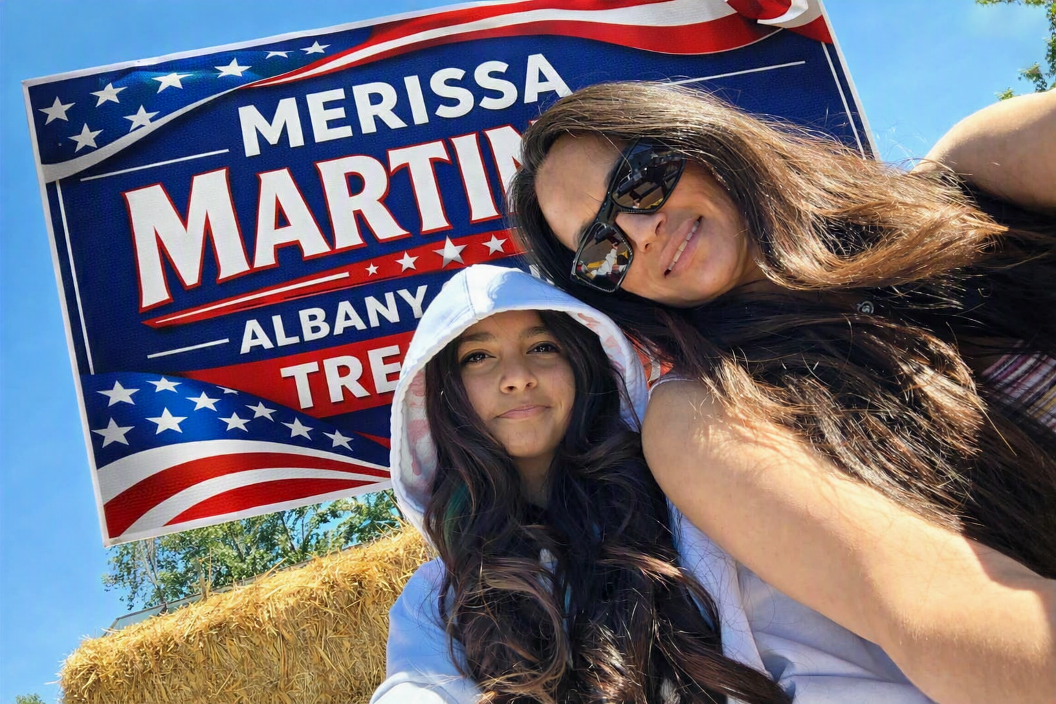 Merissa Martinez with her daughter in front of a campaign yard sign on a sunny day in Albany County, Wyoming